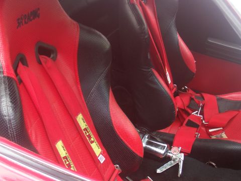 1972 Ford Ranchero - Interior view of custom red and black racing seats with harnesses and a fire extinguisher visible.