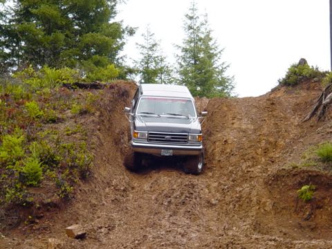 1989 Ford Bronco - 1989 Ford Bronco navigating a challenging off-road terrain.