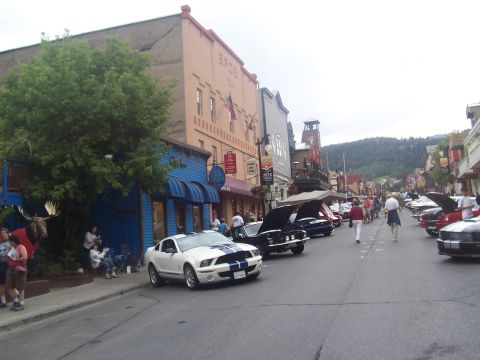 1972 Ford Ranchero - Street lined with classic and modern cars, people walking, and historic buildings.
