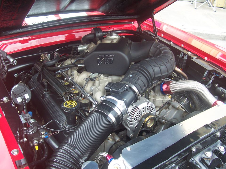 Close-up of a V10 engine with a large air intake tube and alternator
