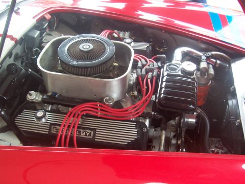 1972 Ford Ranchero - Close-up of a vehicle's engine bay, Shelby valve covers and bright red spark plug wires.