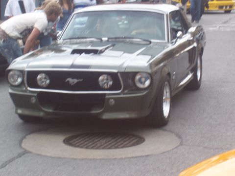 1972 Ford Ranchero - A classic Ford Mustang is parked on a street, with people gathered around.