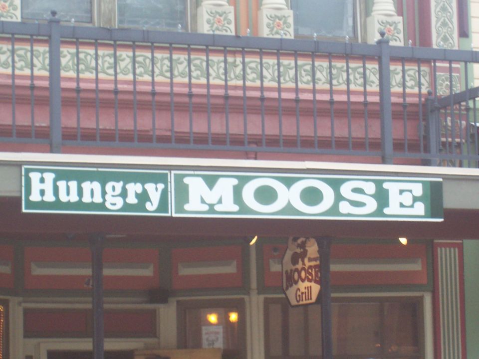Sign for Hungry Moose Grill with decorative railing above