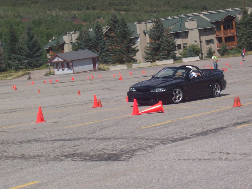 Black convertible sports car on autocross course, front 3/4 view