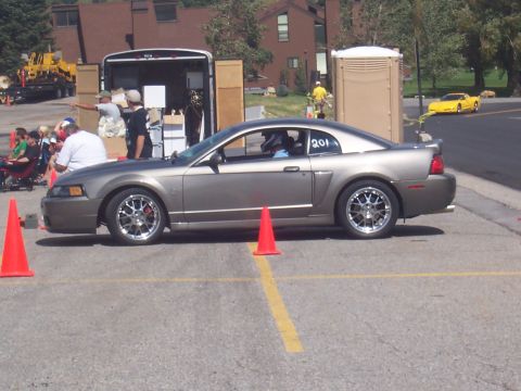 1972 Ford Ranchero - Side view of a 2000 Ford Mustang with racing number 201, yellow Corvette in background.