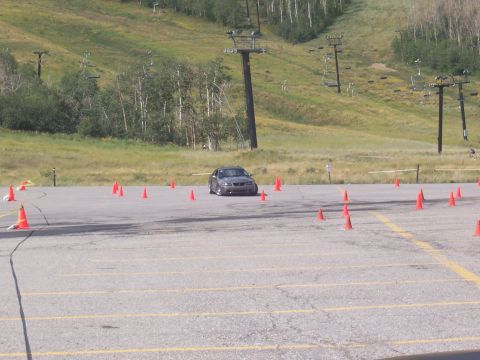 1972 Ford Ranchero - A car drives through an autocross course marked by orange cones, with a ski slope visible behind it.