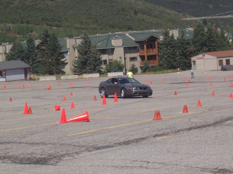 1972 Ford Ranchero - A gray Ford Mustang navigates a course marked by orange cones in an open lot.