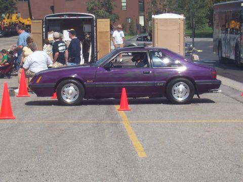 1972 Ford Ranchero - A purple Ford Mustang GT is parked on a lot with orange cones marking a course.