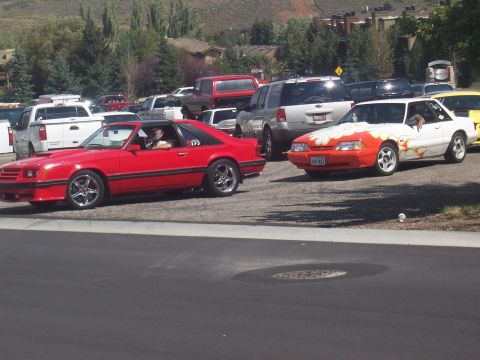 1972 Ford Ranchero - A red coupe is parked next to a white car with flame decals.