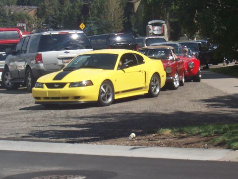 1972 Ford Ranchero - A yellow Ford Mustang is parked in a line of vehicles, with other cars visible behind it.