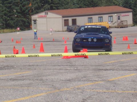 1972 Ford Ranchero - A blue Ford Mustang Shelby GT500 is positioned on a course marked by orange cones and yellow caution tape.