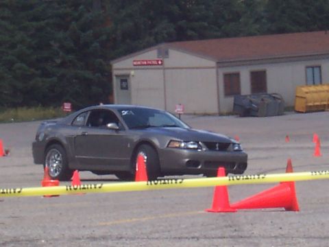 1972 Ford Ranchero - A gray coupe, possibly a Ford Mustang from the early 2000s, navigates a course marked by cones and caution tape.
