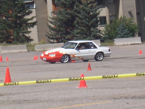 1972 Ford Ranchero - A white coupe with a red front and flame decals navigates a course marked by cones and caution tape.