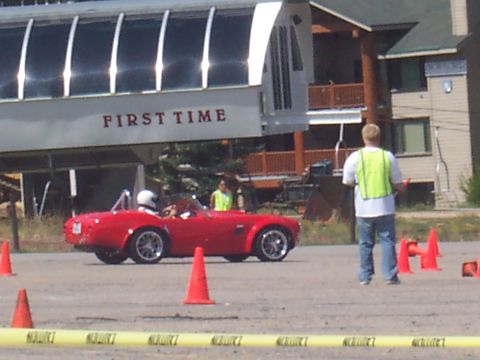 1972 Ford Ranchero - A red convertible sports car is seen on a track with orange cones and a ski lift in the background.