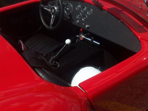 1972 Ford Ranchero - Interior view of a red sports car, black seats, a steering wheel, and a dashboard with several gauges.