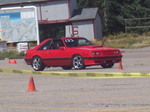1972 Ford Ranchero - A red coupe with racing number 133 is positioned on a track with orange cones and yellow caution tape.