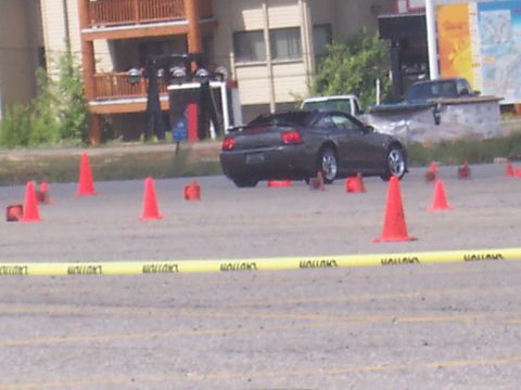 1972 Ford Ranchero - A dark-colored coupe with its top down is positioned on a paved surface marked with orange cones.
