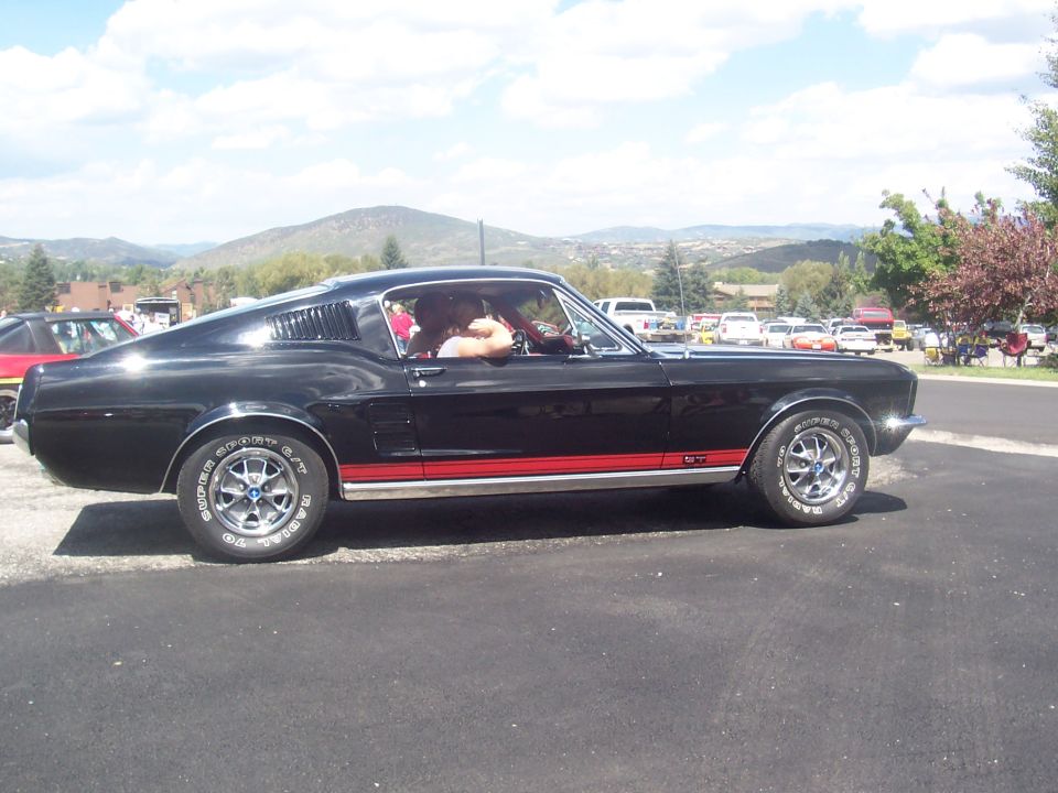 Black 1967 Ford Mustang Fastback with red side stripe and GT emblem