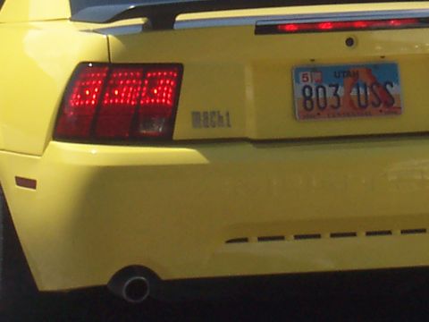 1972 Ford Ranchero - The rear of a yellow Ford Mustang Mach 1 shows its distinctive taillights and 'Mach 1' badging.