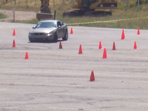 1972 Ford Ranchero - A silver coupe is seen from a 3/4 front angle, maneuvering through a cone course on a paved surface.