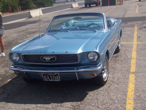 1972 Ford Ranchero - Blue 1965 Ford Mustang convertible parked in a lot.