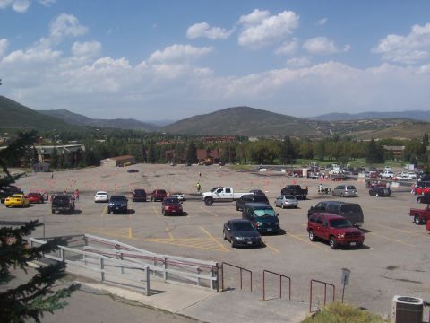 1972 Ford Ranchero - A wide view of a parking lot filled with various vehicles under a partly cloudy sky.