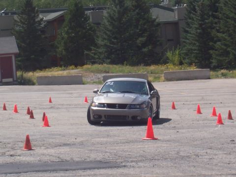 1972 Ford Ranchero - 2001 Ford Mustang Cobra navigating a slalom course with orange cones.