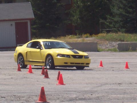 1972 Ford Ranchero - A yellow Ford Mustang is shown on a track with orange cones, likely participating in a timed event.