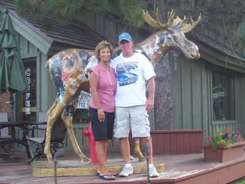1972 Ford Ranchero - A couple stands in front of a coffee shop next to a large moose statue decorated with dog portraits.
