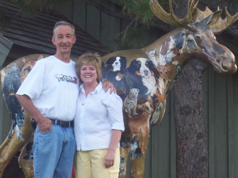 1972 Ford Ranchero - A man and woman pose in front of a large moose sculpture adorned with numerous dog portraits.