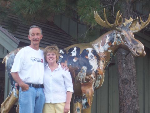 1972 Ford Ranchero - A couple stands next to a large moose sculpture that has been intricately painted with numerous dog portraits.