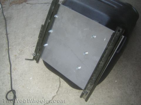 1987 Suzuki Samurai - Custom seat bracket with bolts attached to a black seat base, likely for a vehicle modification.