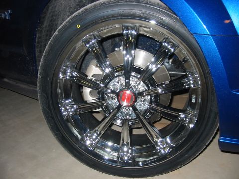 1993 Ford Taurus - Close-up of a shiny chrome wheel on a blue vehicle.