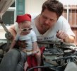 1995 Ford Bronco - Father and child attend to engine maintenance, baby sports cool shades.