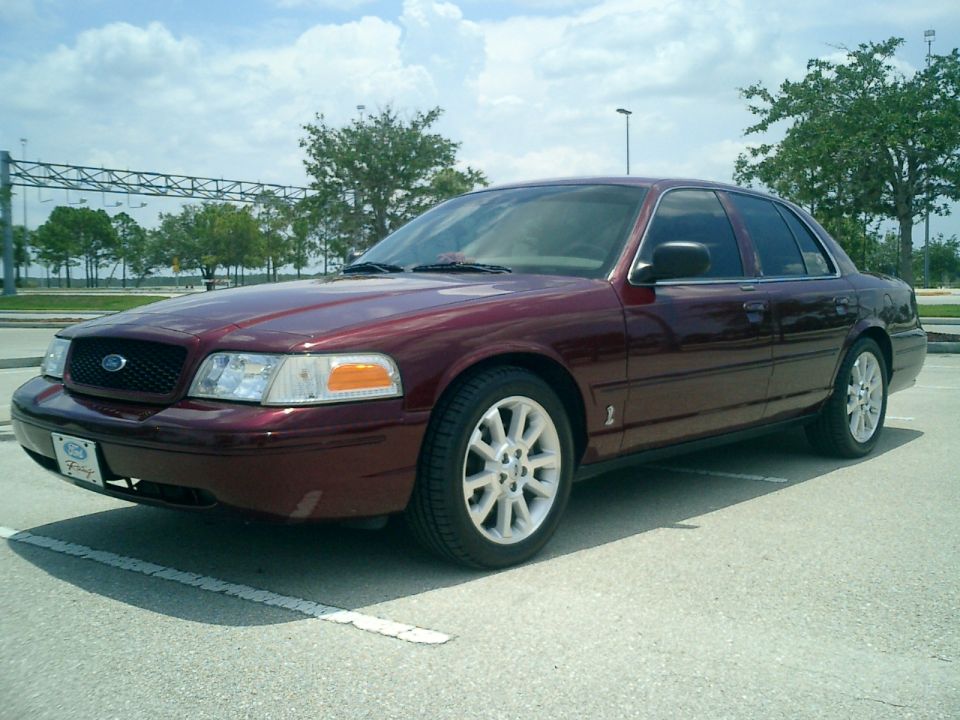 Maroon sedan, 3/4 front view, parked on asphalt