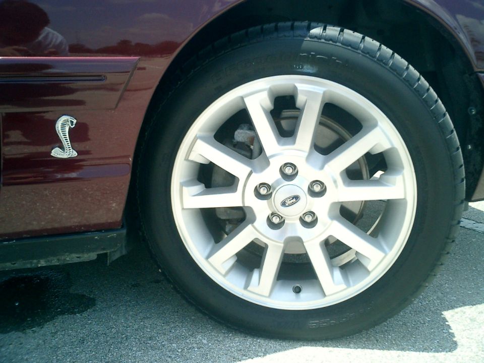Maroon 2004 Ford Crown Victoria side view showing a cobra emblem on the fender