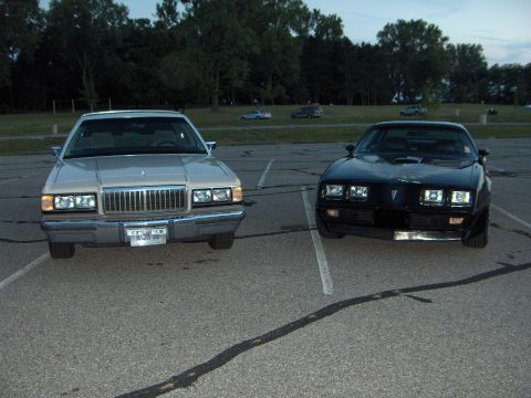 1988 Mercury Grand Marquis - A tan 1988 Mercury Grand Marquis is parked next to a black car in a parking lot.
