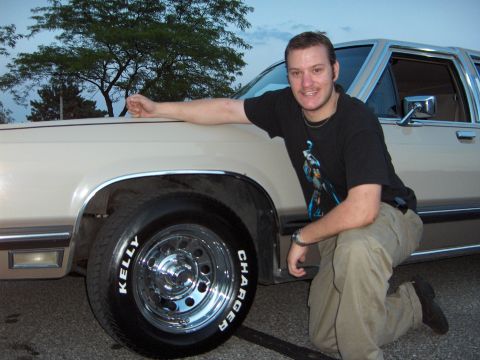 1988 Mercury Grand Marquis - Man poses with a 1988 Mercury Grand Marquis, highlighting its side profile and custom wheels.