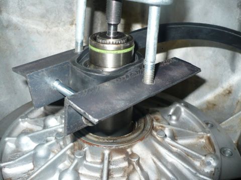 1995 Ford Bronco - A bearing puller tool is used to remove a bearing from a vehicle's transmission housing.