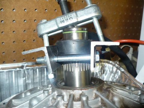 1995 Ford Bronco - A bearing puller tool is used on a transmission part with a splined shaft.
