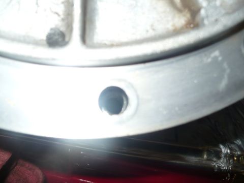 1995 Ford Bronco - A close-up view of a metal component, possibly from a vehicle's engine or drivetrain, showing a drilled hole.