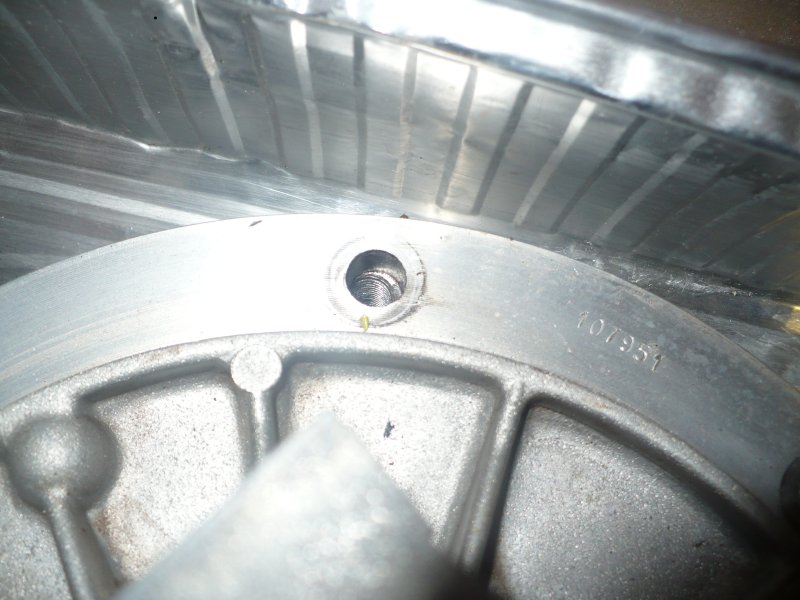 Close-up of a metal engine part with a serial number 107951 stamped on it