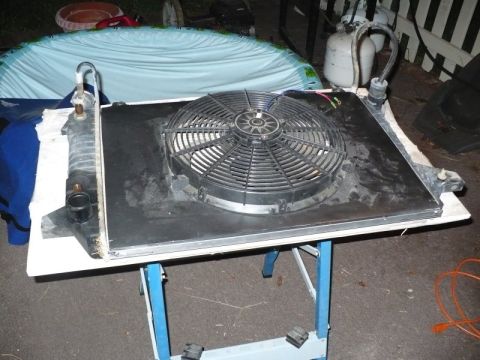 1995 Ford Bronco - Radiator and electric fan assembly on a table, with a blue tarp in the background.