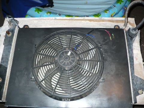 1995 Ford Bronco - Close-up of a radiator assembly with an electric fan mounted to it.
