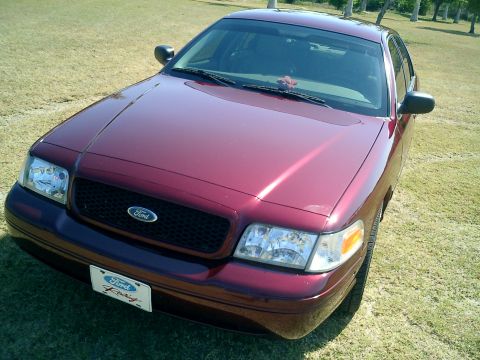 2004 Ford Crown Victoria - A maroon Ford Crown Victoria is shown from a three-quarter front angle, parked outdoors on a grassy area.