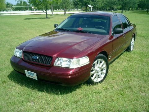2004 Ford Crown Victoria - A maroon 2004 Ford Crown Victoria is shown from a three-quarter front view on a grassy lawn.