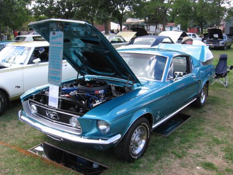 1989 Ford Mustang - This teal 1967 Ford Mustang coupe is displayed with its hood open, revealing the engine bay.