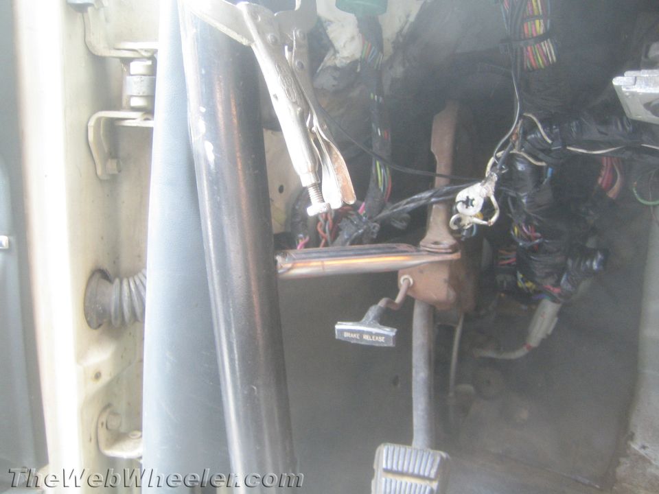 Vehicle footwell with brake pedal, brake release lever and wiring harness