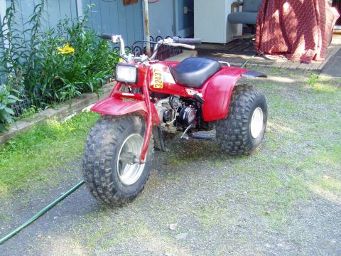 2000 Ford E350 - This red three-wheeled ATV features large, knobby tires and a visible yellow number plate with the digits 32437.