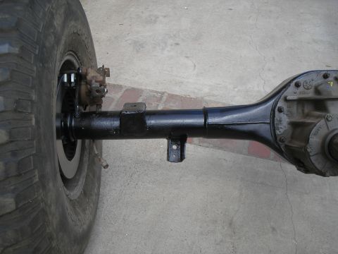 1990 Ford Bronco - Close-up of a vehicle's rear axle assembly and tire.